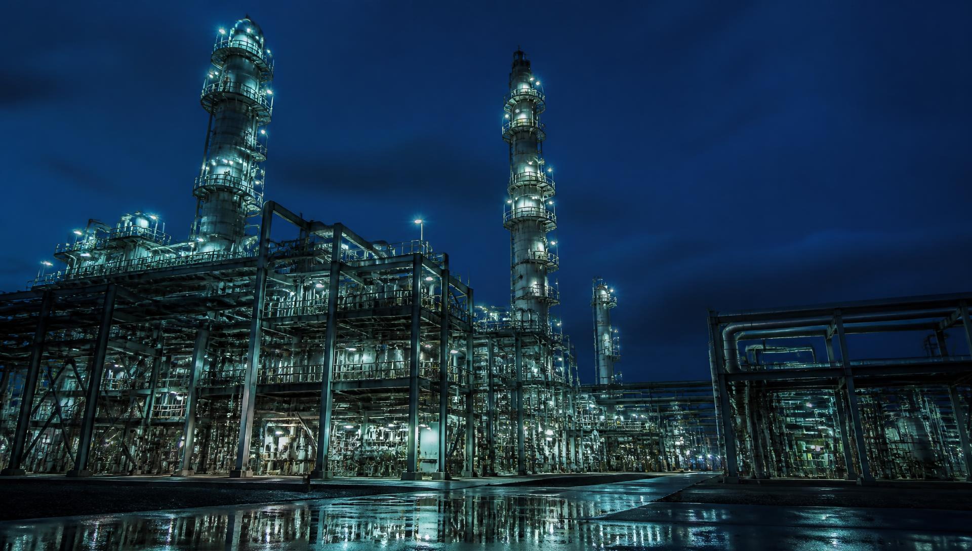 Oil and gas processing facility illuminated at dusk